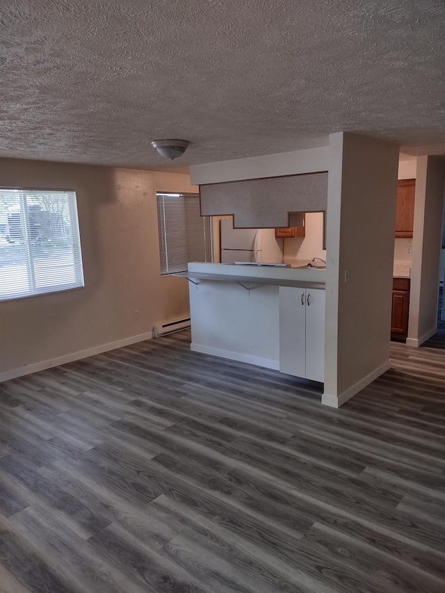 108 E Weile Ave # 1, Spokane, WA 99208 - kitchen featuring a peninsula, a textured ceiling, a baseboard radiator, dark wood-type flooring, and open floor plan