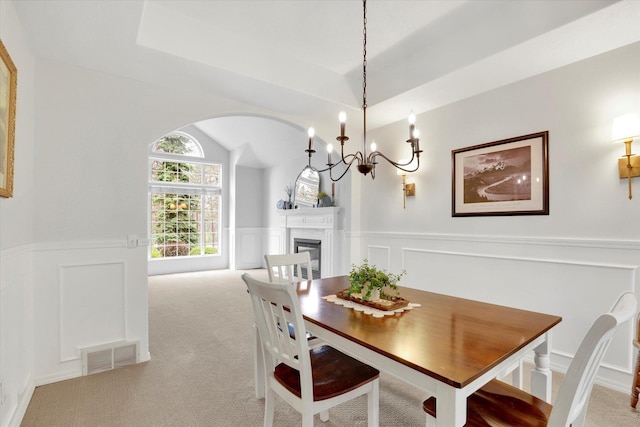 16906 N Golden Dr, Colbert, WA 99005 - carpeted dining room with a decorative wall, a glass covered fireplace, a wainscoted wall, arched walkways, and a chandelier