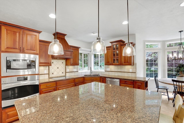 16906 N Golden Dr, Colbert, WA 99005 - kitchen with appliances with stainless steel finishes, brown cabinetry, dark stone counters, decorative backsplash, and recessed lighting