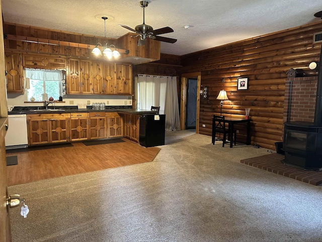 2267 Hawks Rd, Colville, WA 99114 - kitchen featuring a wood stove, dark countertops, brown cabinets, a textured ceiling, and a ceiling fan