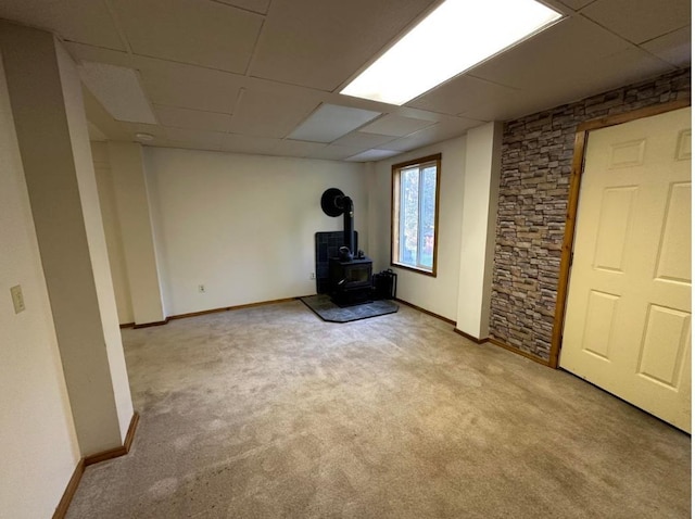 2267 Hawks Rd, Colville, WA 99114 - basement featuring a wood stove, a paneled ceiling, baseboards, and carpet floors