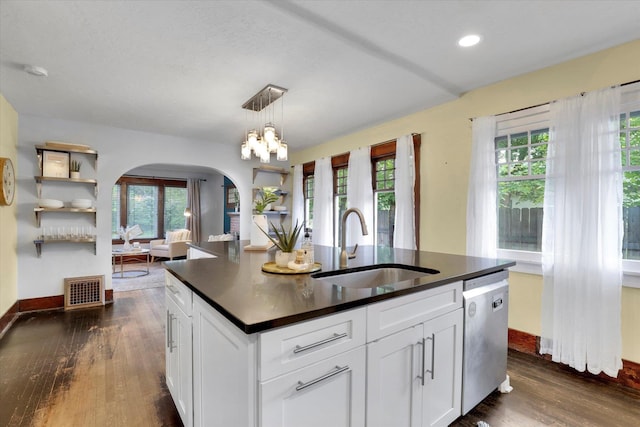 7311 E Fairview Ave, Spokane Valley, WA 99212 - kitchen with stainless steel dishwasher, a sink, arched walkways, dark countertops, and healthy amount of natural light