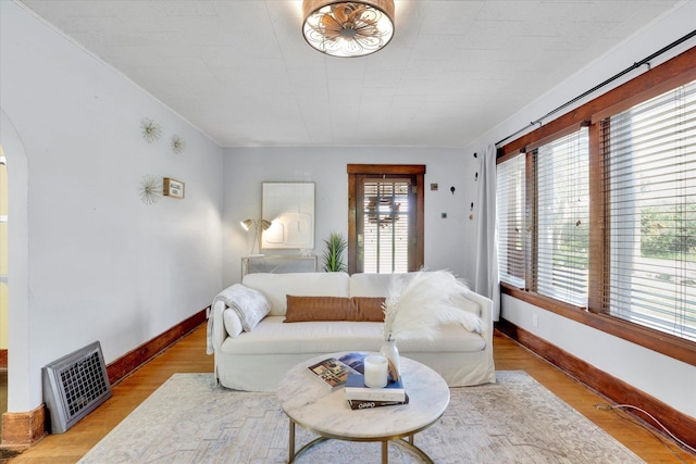 7311 E Fairview Ave, Spokane Valley, WA 99212 - living area featuring baseboards, arched walkways, heating unit, and wood finished floors