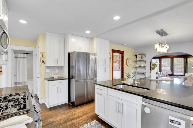 7311 E Fairview Ave, Spokane Valley, WA 99212 - kitchen with appliances with stainless steel finishes, dark countertops, a sink, white cabinetry, and decorative backsplash