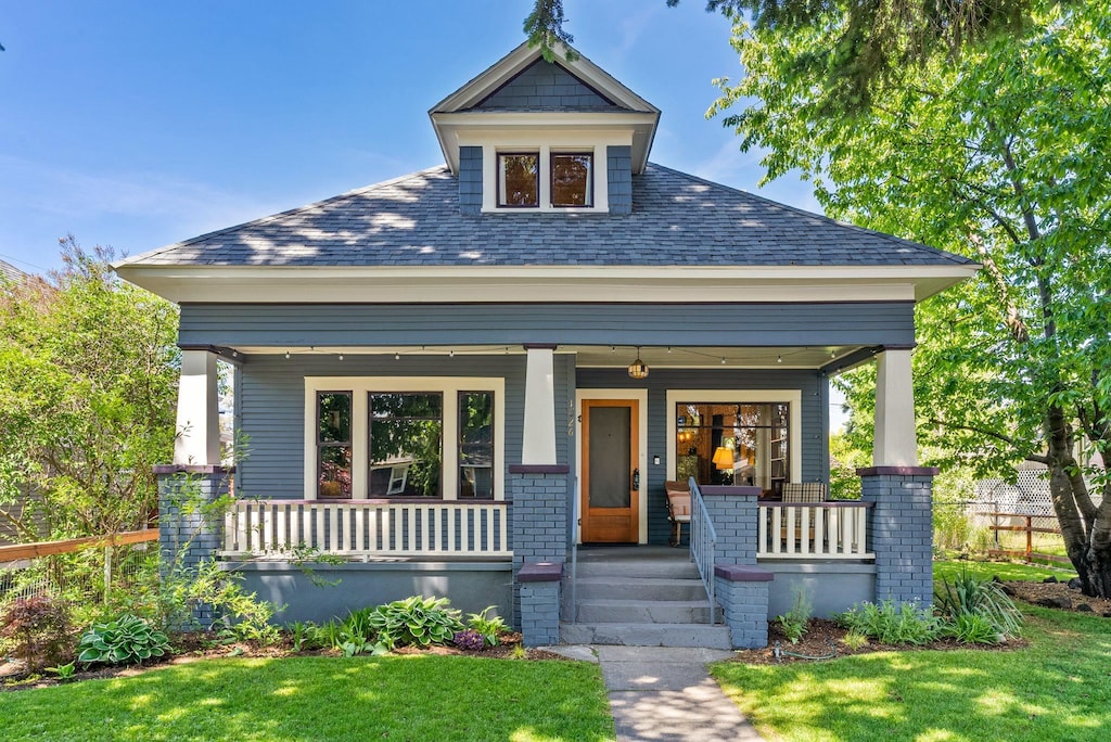 1026 W Grace Ave, Spokane, WA 99205 - view of front of home with covered porch, a front yard, and a shingled roof