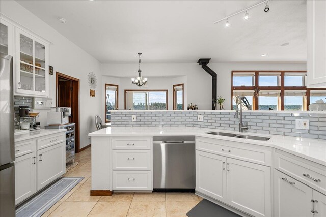 16503 W Bluebird Ln, Spokane, WA 99224 - kitchen with dishwasher, a sink, decorative backsplash, and a chandelier