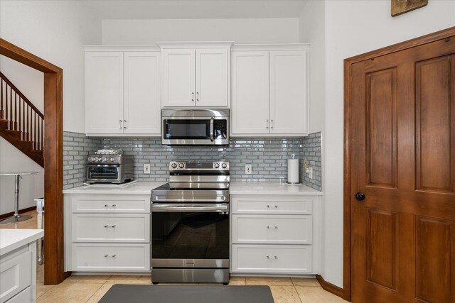 16503 W Bluebird Ln, Spokane, WA 99224 - kitchen with stainless steel appliances, light countertops, decorative backsplash, and white cabinets