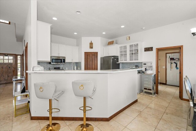 16503 W Bluebird Ln, Spokane, WA 99224 - kitchen with stainless steel appliances, a peninsula, decorative backsplash, white cabinets, and recessed lighting