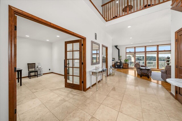 16503 W Bluebird Ln, Spokane, WA 99224 - hall featuring french doors, light tile patterned floors, recessed lighting, a high ceiling, and baseboards