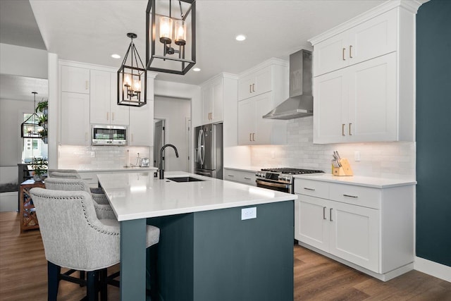 5212 W Decatur Ave, Spokane, WA 99208 - kitchen featuring wall chimney range hood, a sink, stainless steel appliances, dark wood-type flooring, and recessed lighting
