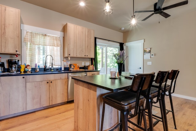 33319 N Conklin Rd, Elk, WA 99009 - kitchen with light brown cabinetry, dishwasher, a sink, dark countertops, and light wood-type flooring