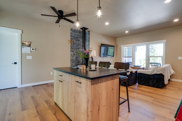 33319 N Conklin Rd, Elk, WA 99009 - kitchen featuring a breakfast bar, dark countertops, open floor plan, a center island, and light wood-type flooring