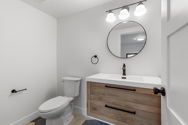 1431 E Miles Ave, Hayden, ID 83835 - bathroom with vanity, toilet, baseboards, and tile patterned floors