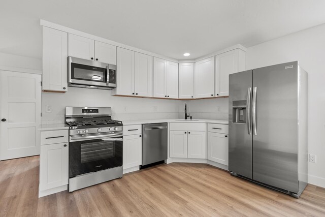 1431 E Miles Ave, Hayden, ID 83835 - kitchen featuring stainless steel appliances, a sink, light countertops, light wood-style floors, and white cabinets