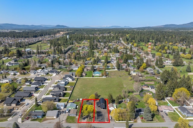 1431 E Miles Ave, Hayden, ID 83835 - aerial perspective of suburban area with property parcel outlined, a mountain backdrop, and a forest