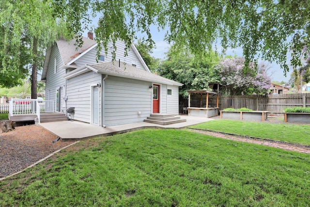 436 N Washington St, Tekoa, WA 99033 - back of property featuring a vegetable garden, roof with shingles, a deck, a chimney, and a patio area
