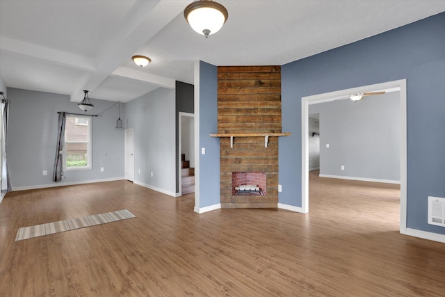 436 N Washington St, Tekoa, WA 99033 - unfurnished living room featuring stairs, beam ceiling, wood finished floors, and baseboards