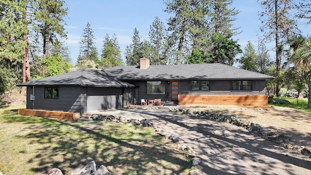 525 S Granite Dr, Spokane Valley, WA 99212 - rear view of house featuring a chimney, a garage, driveway, and a shingled roof