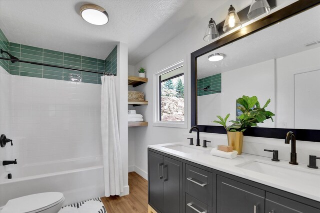 525 S Granite Dr, Spokane Valley, WA 99212 - full bathroom featuring toilet, double vanity, shower / bath combination with curtain, wood finished floors, and a textured ceiling