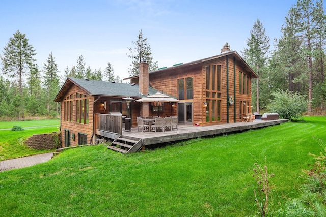5999 E Roger Dr, Post Falls, ID 83854 - rear view of house with a chimney, a yard, outdoor dining space, and a deck