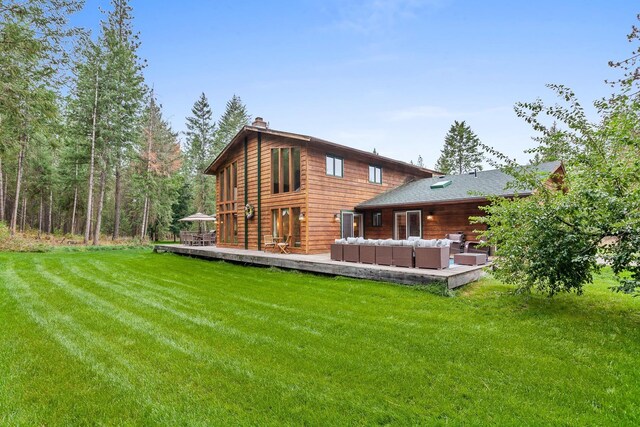 5999 E Roger Dr, Post Falls, ID 83854 - rear view of property featuring an outdoor living space, a wooden deck, a chimney, and a lawn