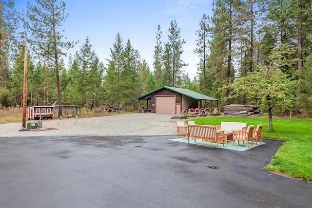 5999 E Roger Dr, Post Falls, ID 83854 - view of patio / terrace with an outdoor structure, a garage, and view of scattered trees