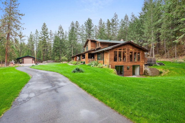 5999 E Roger Dr, Post Falls, ID 83854 - view of front of house featuring an outdoor structure, a detached garage, a front yard, a chimney, and a wooded view