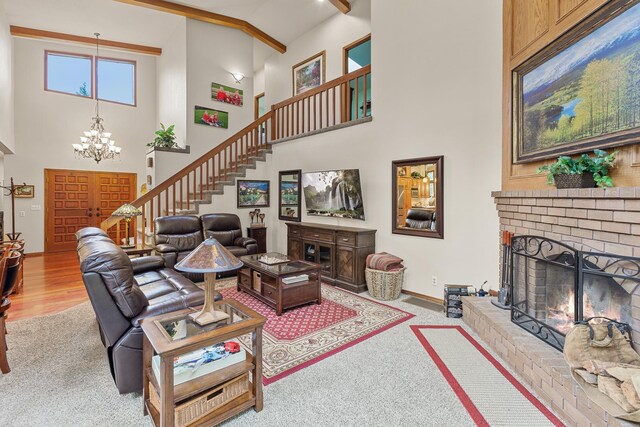 5999 E Roger Dr, Post Falls, ID 83854 - carpeted living room with high vaulted ceiling, stairway, a chandelier, baseboards, and a fireplace