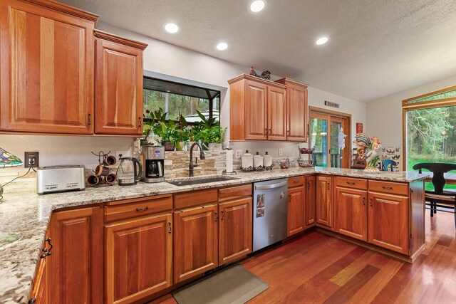 5999 E Roger Dr, Post Falls, ID 83854 - kitchen featuring stainless steel dishwasher, a sink, dark wood finished floors, a peninsula, and light stone counters