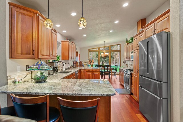 5999 E Roger Dr, Post Falls, ID 83854 - kitchen with appliances with stainless steel finishes, a sink, a peninsula, dark wood-type flooring, and recessed lighting