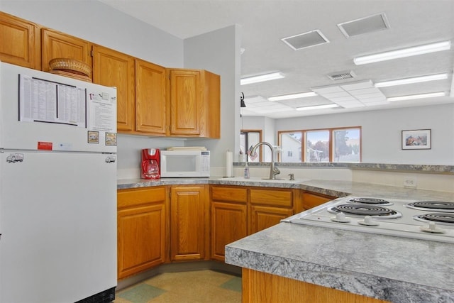 1946 S Century Ln, Spokane Valley, WA 99037 - kitchen featuring white appliances, brown cabinetry, and light countertops
