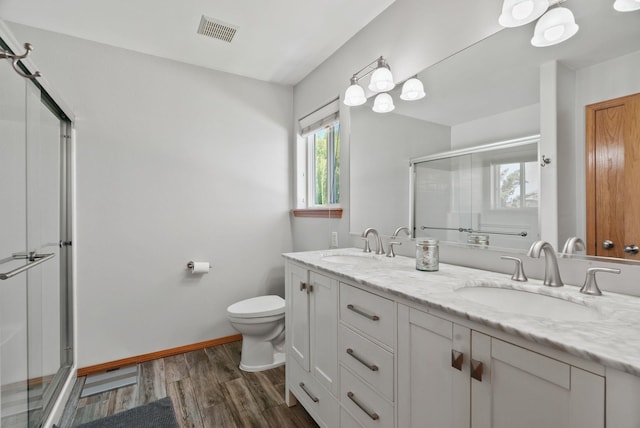 13013 E 37th Ct, Spokane Valley, WA 99206 - full bathroom featuring toilet, a stall shower, wood finished floors, double vanity, and baseboards