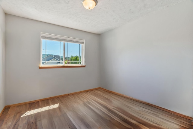 13013 E 37th Ct, Spokane Valley, WA 99206 - unfurnished room featuring wood finished floors, baseboards, and a textured ceiling
