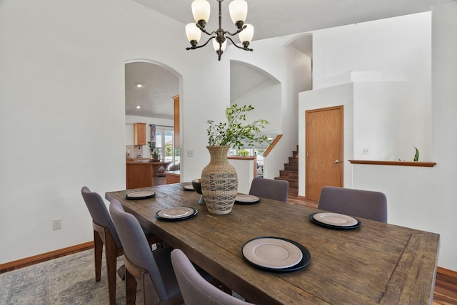 13013 E 37th Ct, Spokane Valley, WA 99206 - dining area featuring a chandelier, stairway, arched walkways, wood finished floors, and baseboards