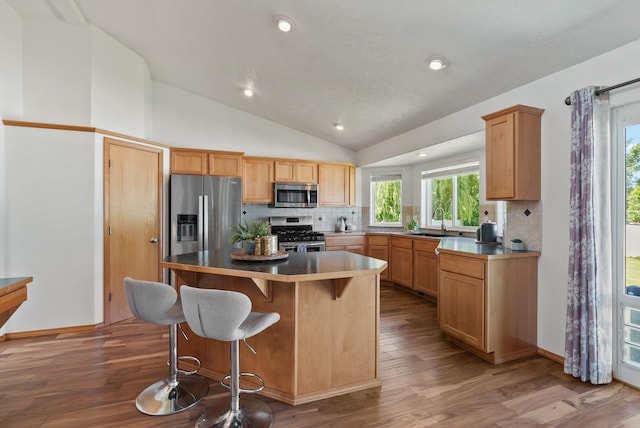 13013 E 37th Ct, Spokane Valley, WA 99206 - kitchen with stainless steel appliances, a sink, tasteful backsplash, lofted ceiling, and wood finished floors