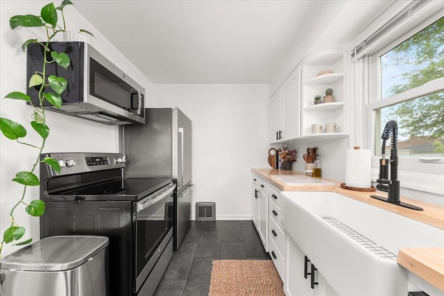 524 E Garland Ave, Spokane, WA 99207 - kitchen featuring appliances with stainless steel finishes, a sink, open shelves, light countertops, and white cabinetry