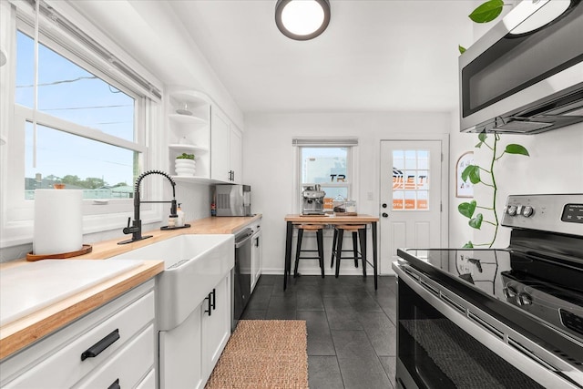 524 E Garland Ave, Spokane, WA 99207 - kitchen with appliances with stainless steel finishes, white cabinets, plenty of natural light, and light countertops