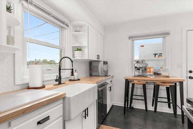 524 E Garland Ave, Spokane, WA 99207 - kitchen featuring stainless steel dishwasher, open shelves, white cabinets, light countertops, and dark tile patterned floors