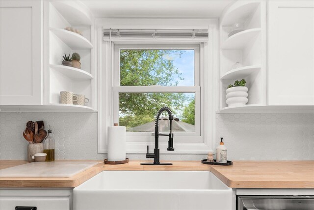 524 E Garland Ave, Spokane, WA 99207 - kitchen view of open shelves, a sink, butcher block counters, white cabinetry, and backsplash