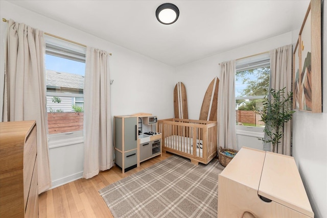 524 E Garland Ave, Spokane, WA 99207 - bedroom featuring light wood-type flooring, baseboards, and a nursery area
