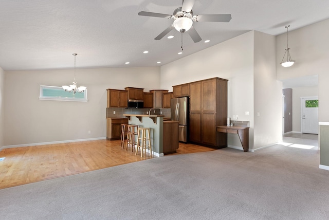 1790 N Winchester St, Liberty Lake, WA 99019 - kitchen with appliances with stainless steel finishes, a breakfast bar, high vaulted ceiling, open floor plan, and a ceiling fan