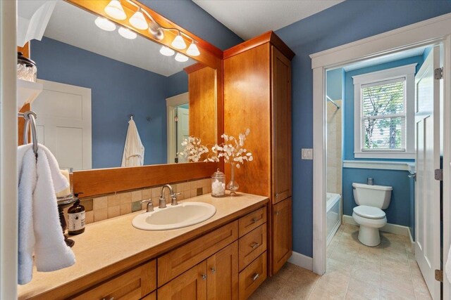 3311 E Chisholm Ln, Spokane, WA 99223 - bathroom with vanity, toilet, shower / bathtub combination, baseboards, and tile patterned flooring