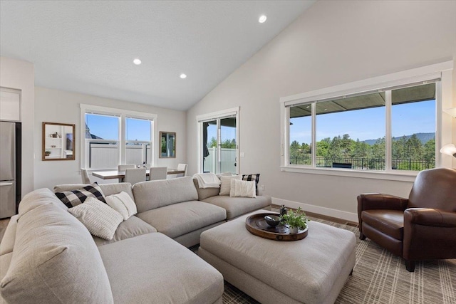 19661 E Riverwalk Ave, Liberty Lake, WA 99016 - living room featuring recessed lighting, baseboards, high vaulted ceiling, and healthy amount of natural light