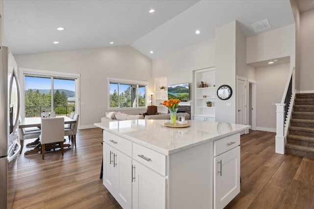 19661 E Riverwalk Ave, Liberty Lake, WA 99016 - kitchen with stainless steel refrigerator with ice dispenser, high vaulted ceiling, a kitchen island, dark wood-style floors, and light stone counters