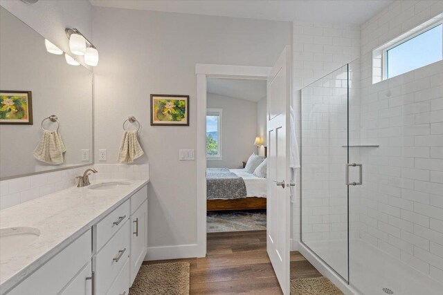 19661 E Riverwalk Ave, Liberty Lake, WA 99016 - bathroom featuring wood finished floors, double vanity, a shower stall, ensuite bathroom, and baseboards