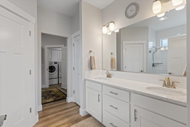 19661 E Riverwalk Ave, Liberty Lake, WA 99016 - bathroom with washer and dryer, a shower stall, double vanity, and wood finished floors