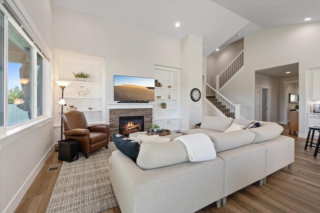 19661 E Riverwalk Ave, Liberty Lake, WA 99016 - living area featuring wood finished floors, baseboards, a towering ceiling, a fireplace, and recessed lighting