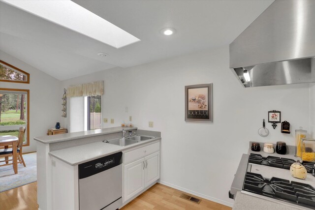 252 N Eagle Dr, Chewelah, WA 99109 - kitchen with dishwashing machine, a sink, wall chimney range hood, a peninsula, and a skylight