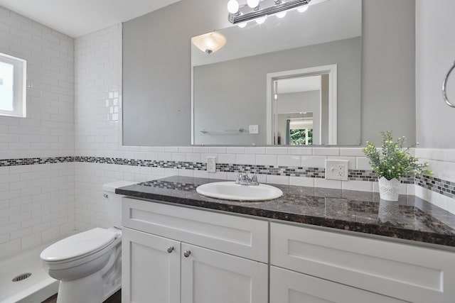 2512 E Rowan Ave, Spokane, WA 99217 - full bathroom featuring vanity, toilet, healthy amount of natural light, decorative backsplash, and tile walls