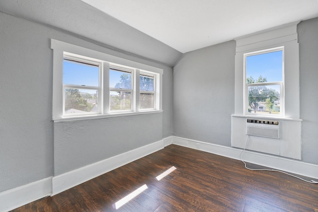 2512 E Rowan Ave, Spokane, WA 99217 - empty room featuring dark wood finished floors, vaulted ceiling, baseboards, and an AC wall unit